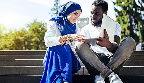 Two international students studying on steps outside